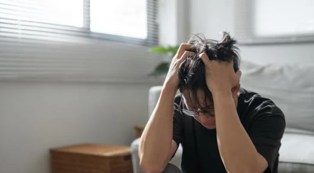 a man holding his head in distress